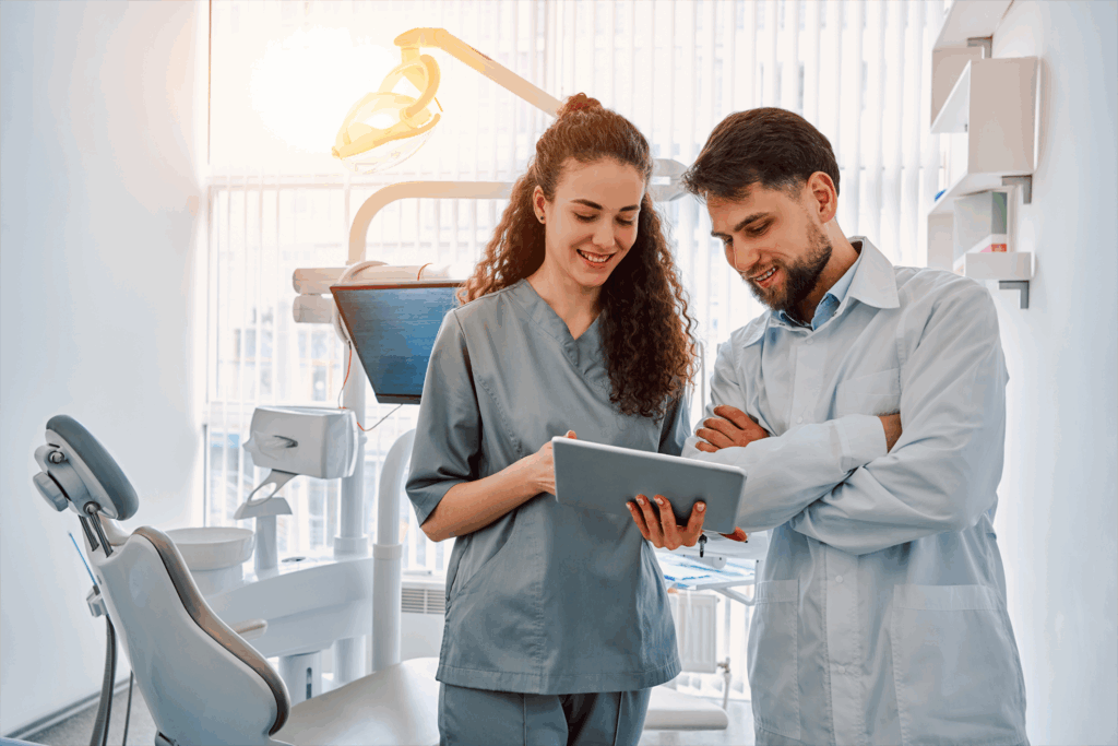 Two dentists looking at a tablet in a dental room